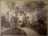 une vieille photo en noir et blanc représentant une femme et un homme dans un jardin