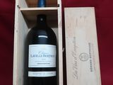 a bottle of wine in a wooden box on a red cloth