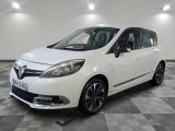 la voiture blanche est garée sur un sol en damier dans le garage