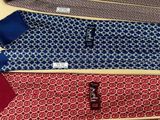 three different colored ties on a table with a tag on them