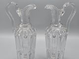 pair of clear glass vases sitting on top of a white surface