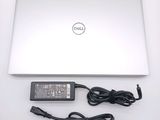 a dell laptop computer with a charger and a power cord