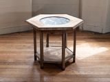 a small wooden table with a glass top on a hard wood floor