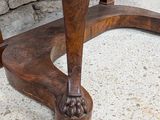 a wooden table with a marble top on a stone floor