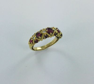 une bague en or jaune sertie de trois rubis au centre