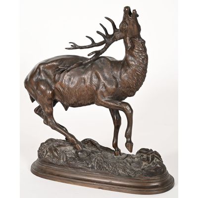 une statue en bronze représentant un cerf sur un rocher, accompagné d'une antilope