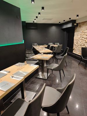 des tables et des chaises dans un restaurant, avec un mur en pierre en arrière-plan
