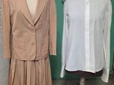 deux mannequins devant une porte verte et une chemise blanche posée sur un support à mannequin