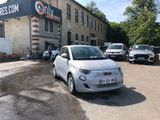a small white car parked in front of a building