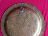 a metal plate that is sitting on a pink cloth