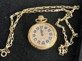 an image of a gold pocket watch with a chain around it