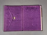 an open book with a purple cover sitting on top of a table