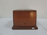 a small wooden box that is on a white surface