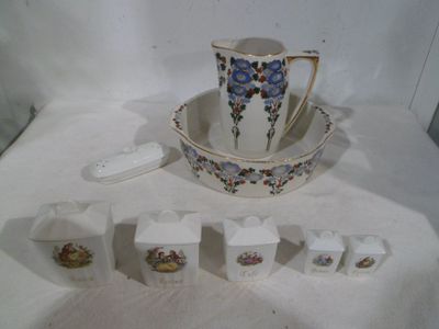 several pieces of porcelain sitting on a table with a cup and saucer