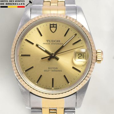 a close up of a watch with a gold dial
