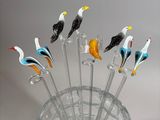 a bunch of birds sitting on top of a glass vase