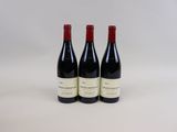trois bouteilles de vin posées sur une table blanche