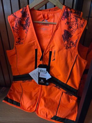 an orange vest with a tag on it sitting on a wooden shelf
