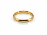 gros plan d'une bague en or sur une surface blanche