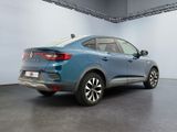 the rear end of a blue car parked in a garage