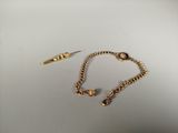 two pairs of gold - plated bracelets and a pair of scissors