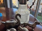 a pitcher and three ducks sitting on a table