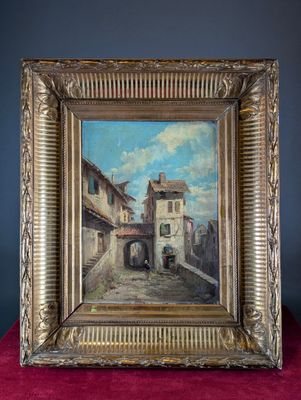 un vieux tableau représentant une scène de rue, dans un cadre doré posé sur un fond rouge