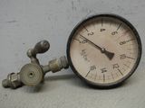 un gros plan d'un manomètre fixé au mur