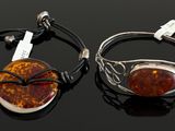 pair of silver and amber bracelets on a black surface