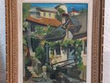an oil painting of a street scene in a frame on a table
