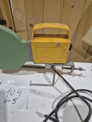 une radio jaune posée sur une table, à côté d'un cordon noir