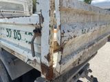 a white truck that has rust on the side of it