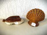 deux figurines en céramique représentant des coquillages, posées sur une table