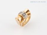 a close up of a gold and diamond ring on a white background
