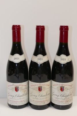trois bouteilles de vin rouge sont alignées sur une table