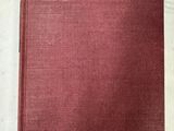 un livre rouge posé sur une table blanche