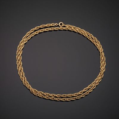 a gold chain bracelet with a clasp on a black background