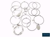 de nombreuses bagues et bracelets en argent posés sur une surface blanche