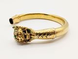 a close up of a gold ring with a green stone in the middle