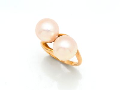 une image représentant deux perles roses dans une bague en or, sur fond blanc