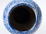 a blue and white vase sitting on a white surface