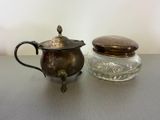 a small glass jar with a metal lid next to a small glass jar with a metal lid