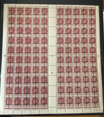 une vieille photo montrant une feuille de timbres rouges et blancs posée sur une table