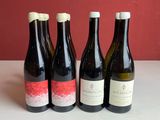 quatre bouteilles de vin sont alignées sur une table
