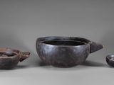 three pieces of pottery sitting on top of a table next to each other