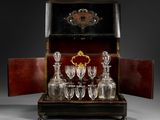 bottles and glasses are sitting on a tray with a wooden case