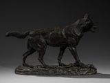 bronze statue of a dog on a rock on a white surface