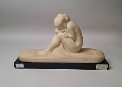statue of a woman sitting on a bench with her head in her hands