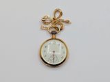 a close up of a gold pocket watch on a white surface