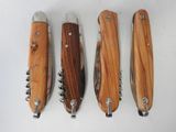 four different types of knives are lined up on a white surface